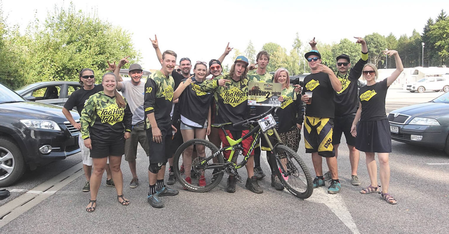 Group of Too High To Die riders and fans in team jerseys at an MTB event
