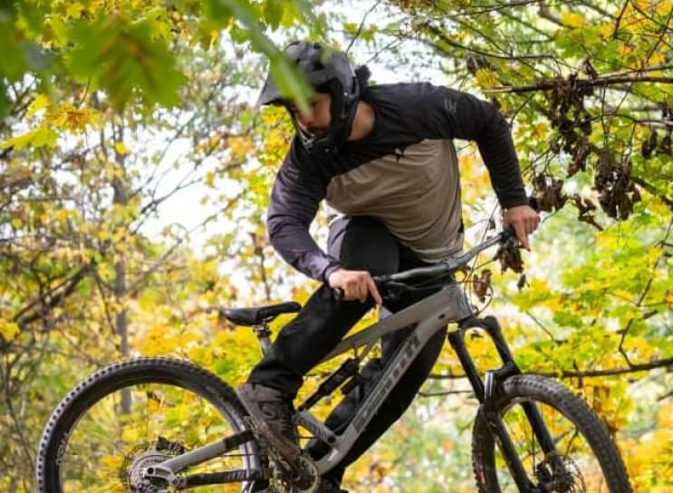A rider balancing on a mountain bike in an autumn forest