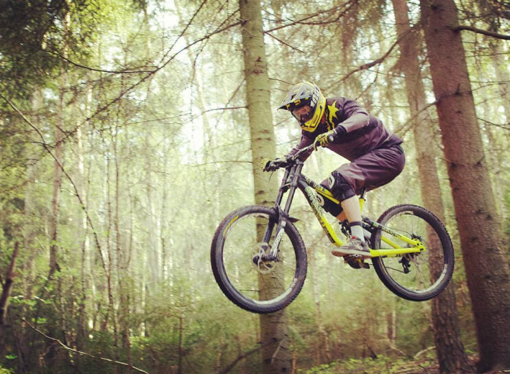 Mountain biker jumping on a forest trail