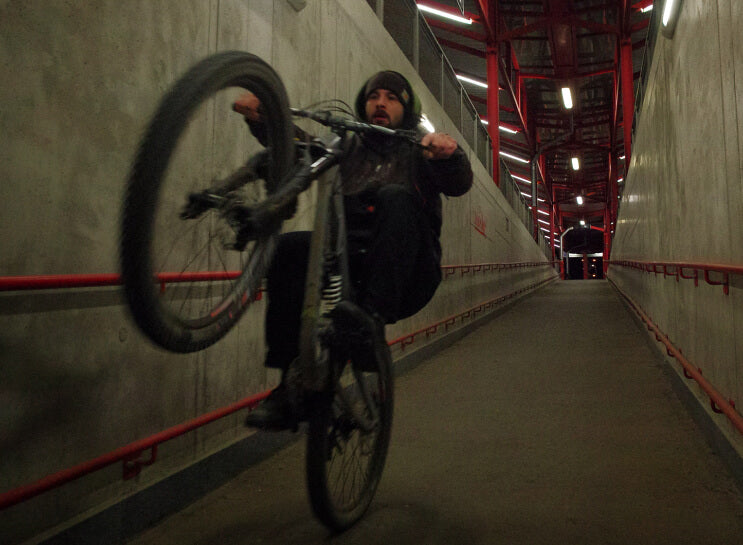 Wheelie on a mountain bike in a concrete underpass at night